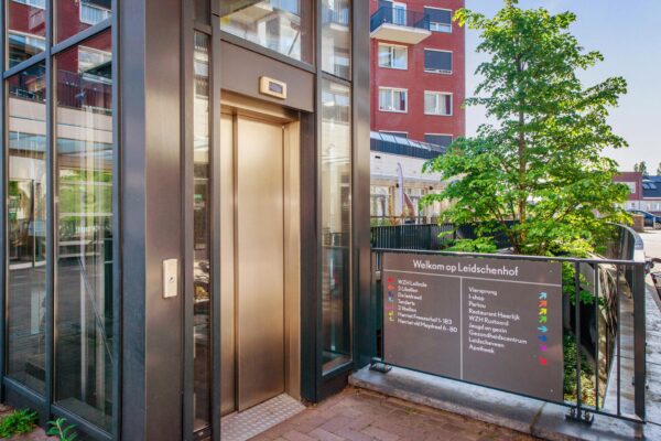Ingang met lift en verwijsbord bij wooncomplex Harriet Freezerhof op de Leidschenhof.